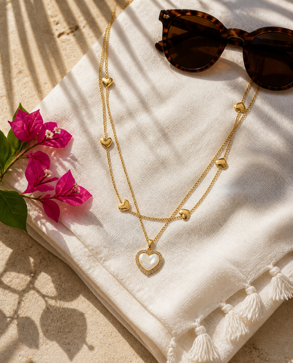 Layered Heart Necklace on a linen sarong with sunglasses