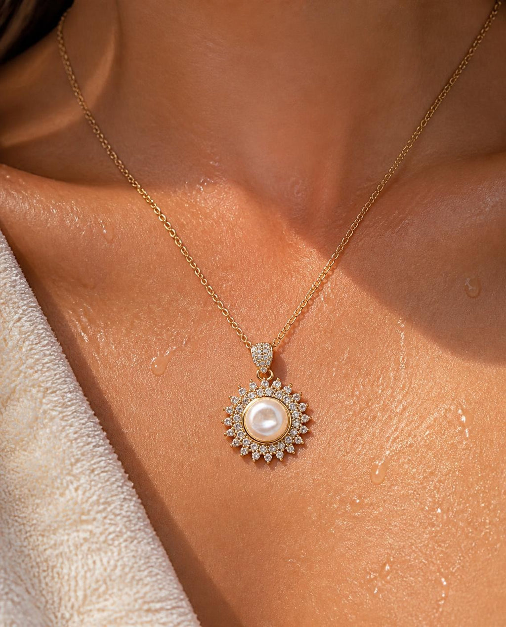 Close-up of the Pearl Sunburst pendant worn on the collarbone