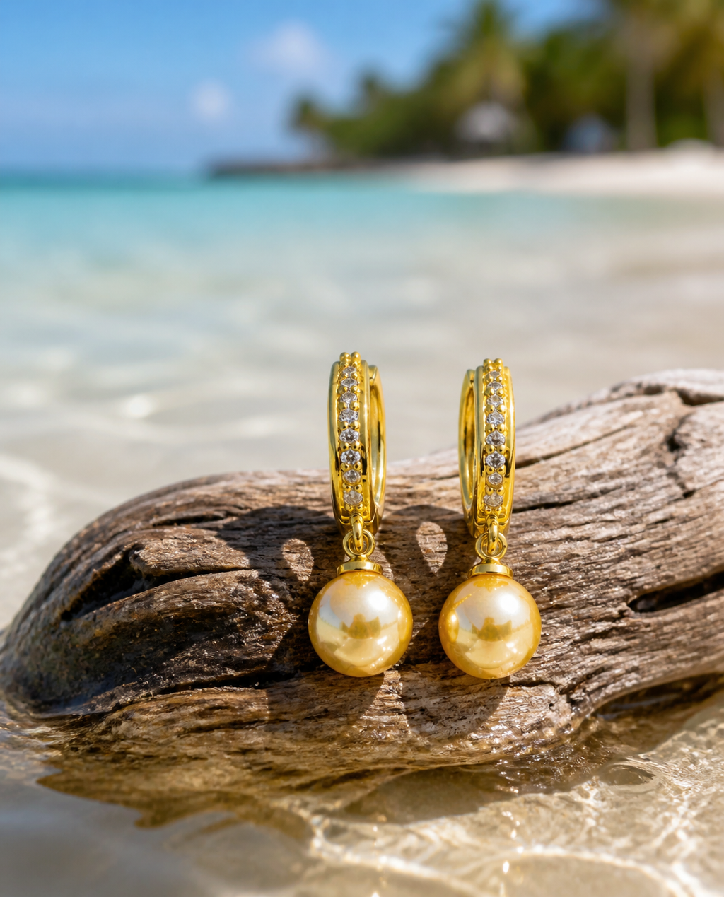 Golden Pearl Drop Hoops on driftwood at the waterline