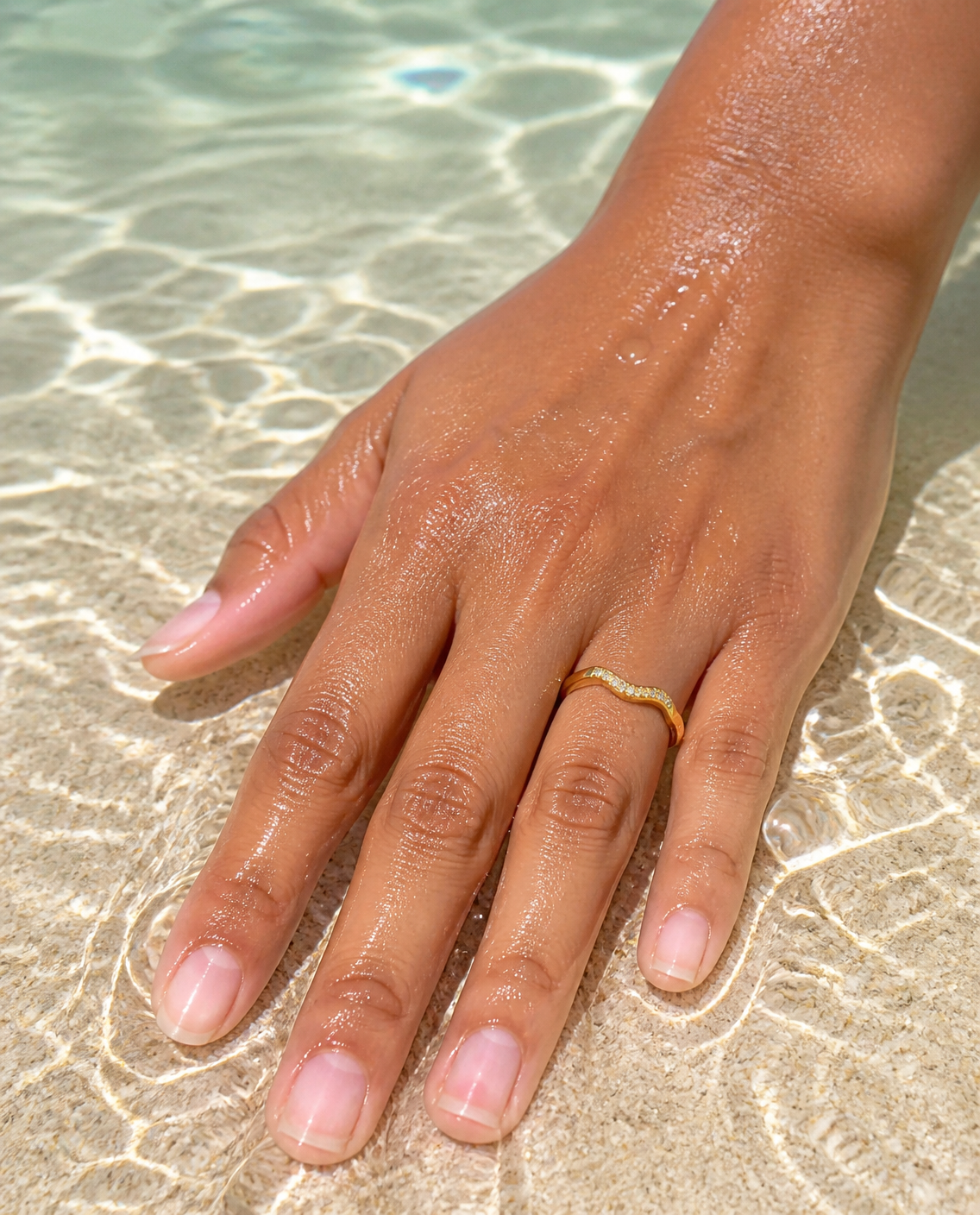 Textured Band Ring worn on a hand in shallow sea water