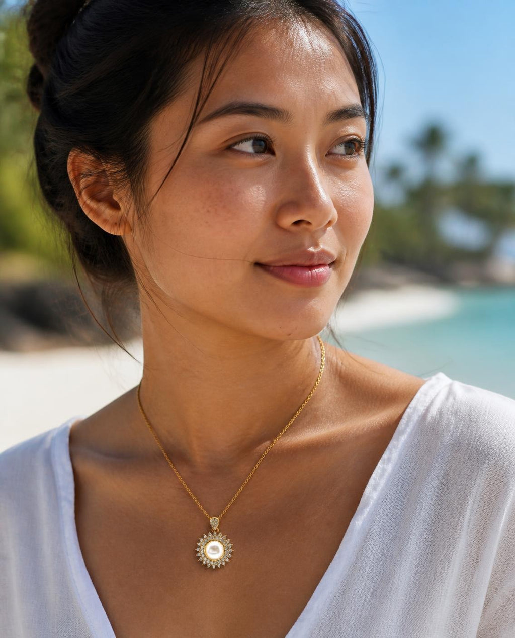 Model wearing the Pearl Sunburst Necklace on the beach
