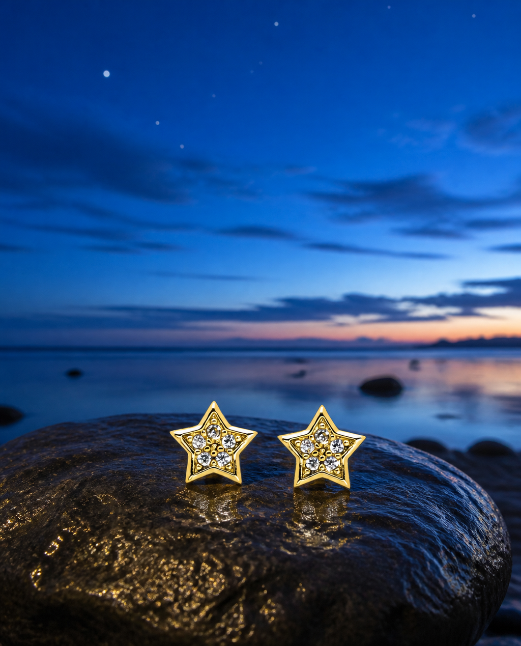 Sparkle Star Stud Earrings on a beach stone at blue hour