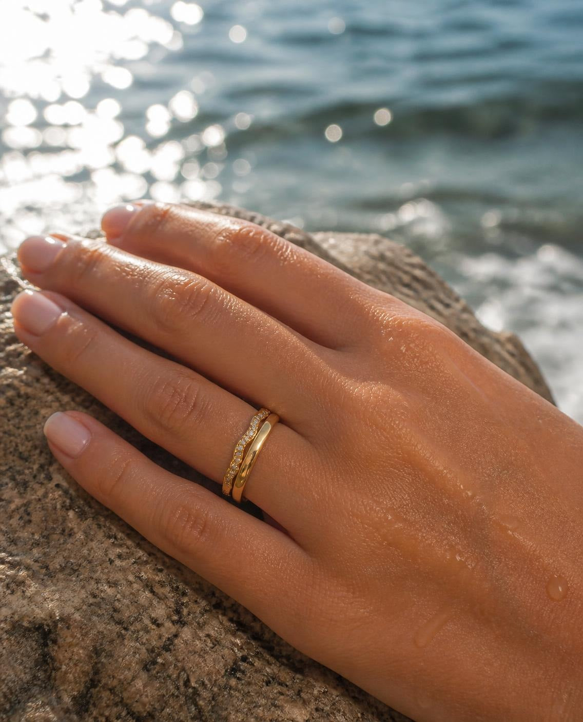 Textured Band Ring stacked with a thin band on a hand by the sea