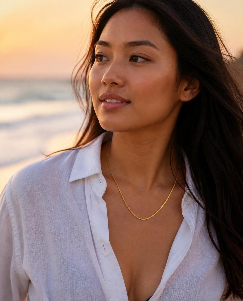 Model on the shoreline at sunset wearing the Dainty Layering Chain