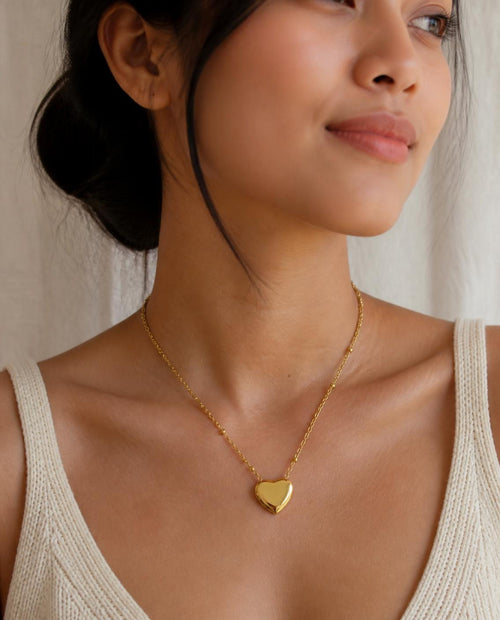 Model wearing the Puffy Heart Necklace with a cream knit top