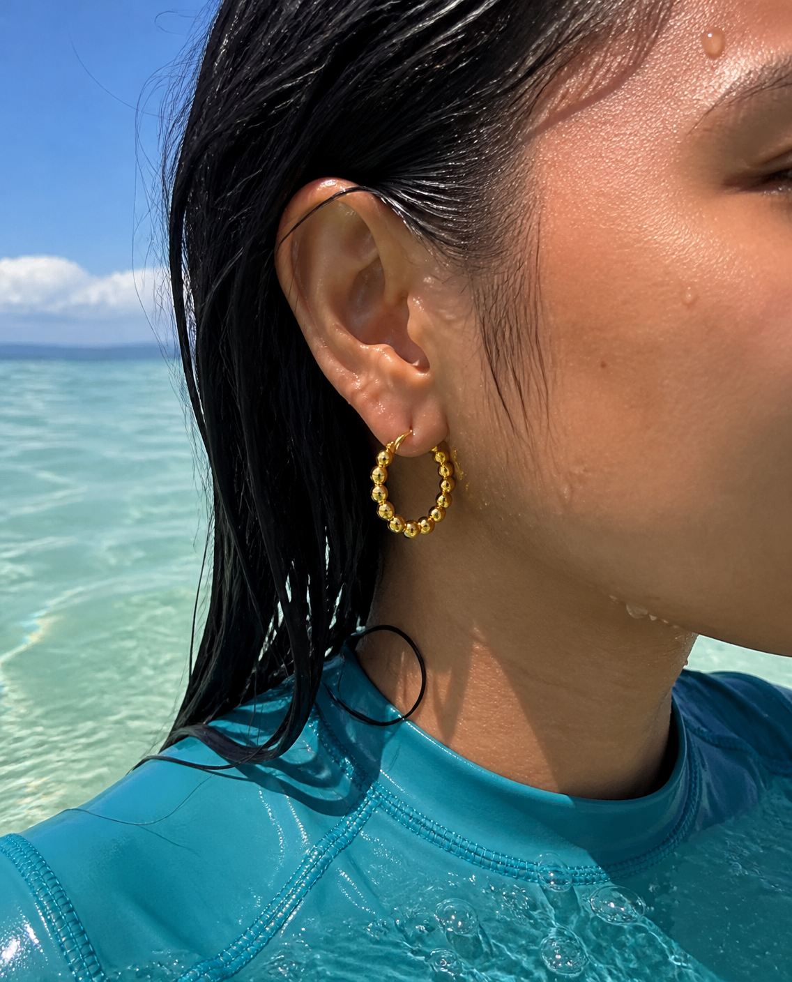 Beaded Bubble Hoops worn in the sea, ear close-up