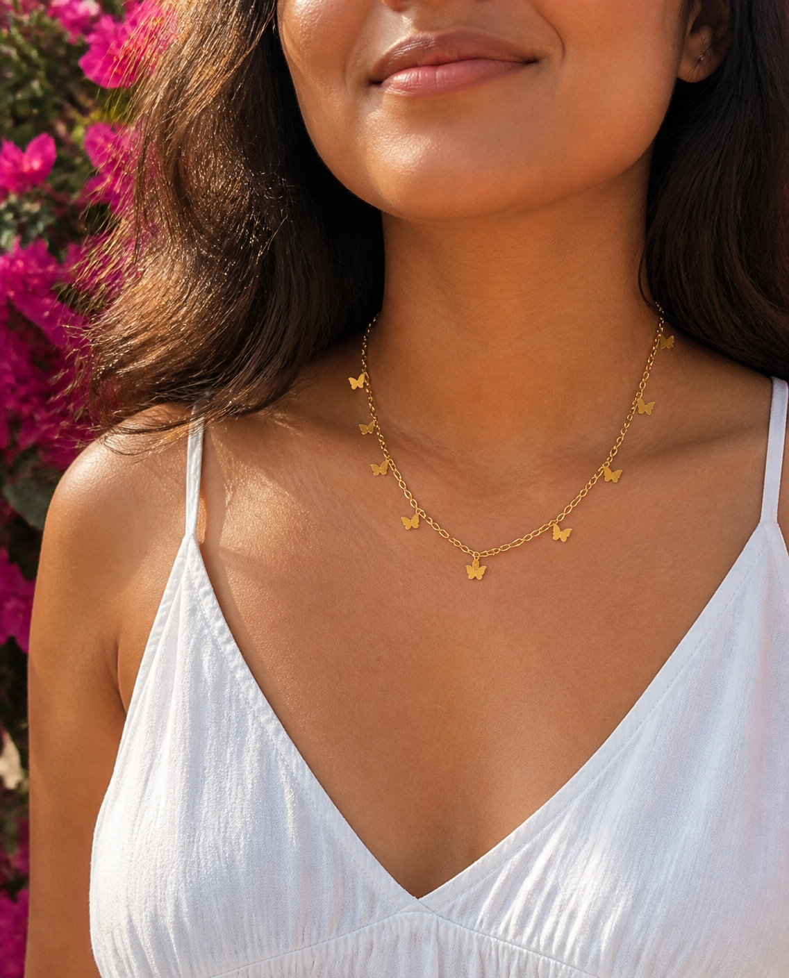Butterfly Charm Necklace worn by a model with bougainvillea