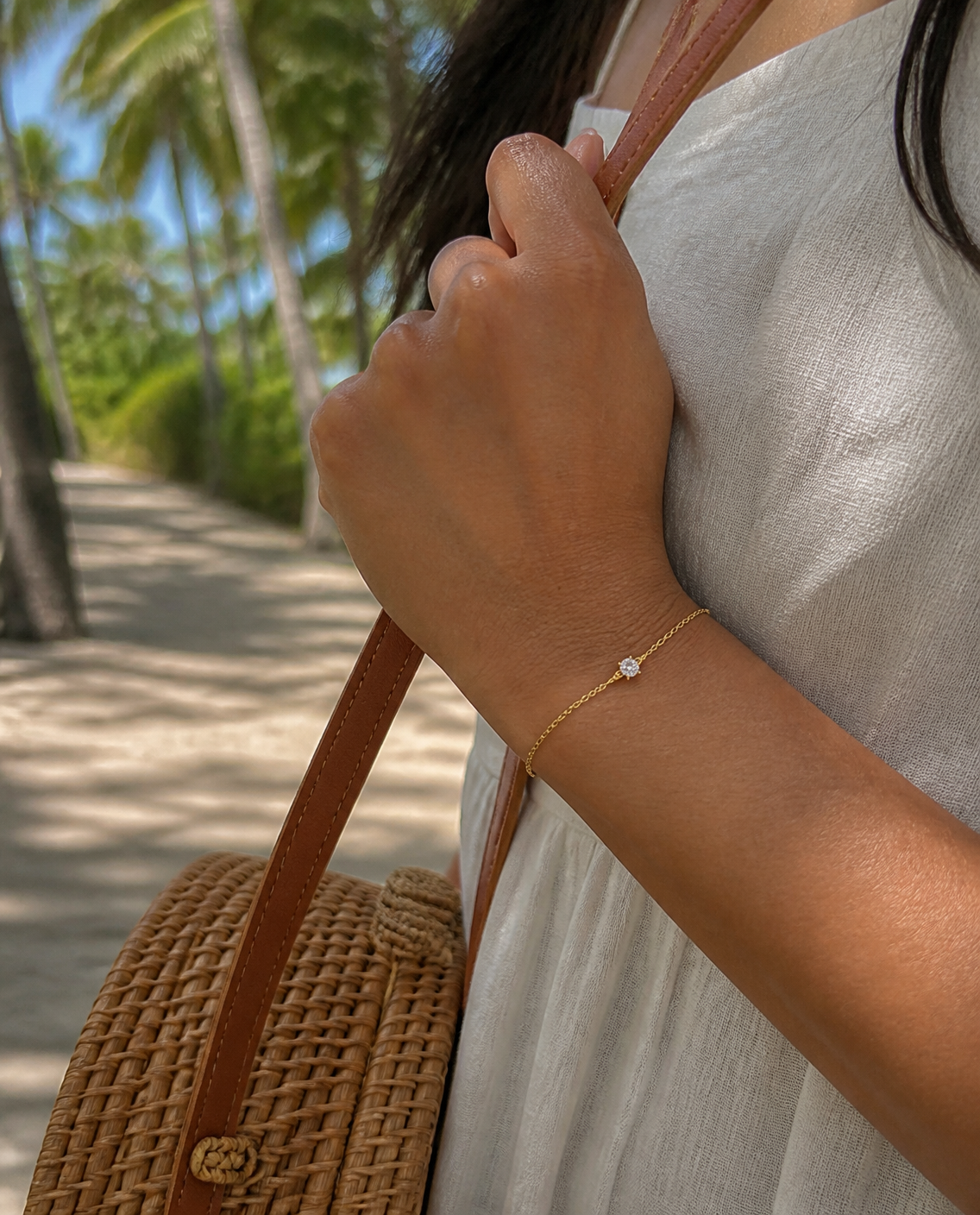 Solitaire Chain Bracelet worn with a rattan bag
